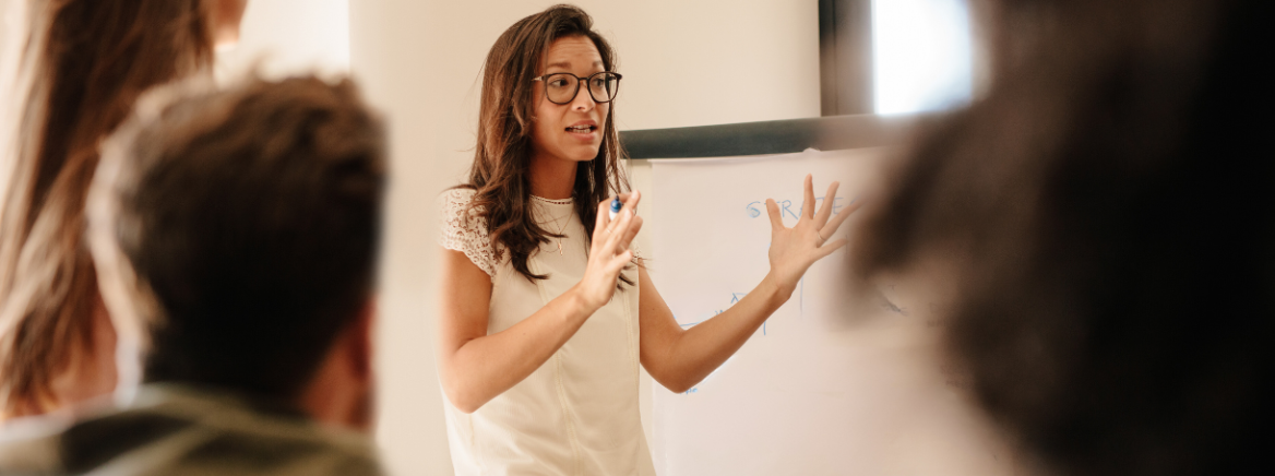 A lady giving a speech to a group o people.