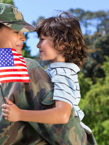 A female veteran with a young child holing an American flag